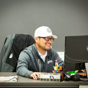 Smiling estimator in a cap at a desk with a computer