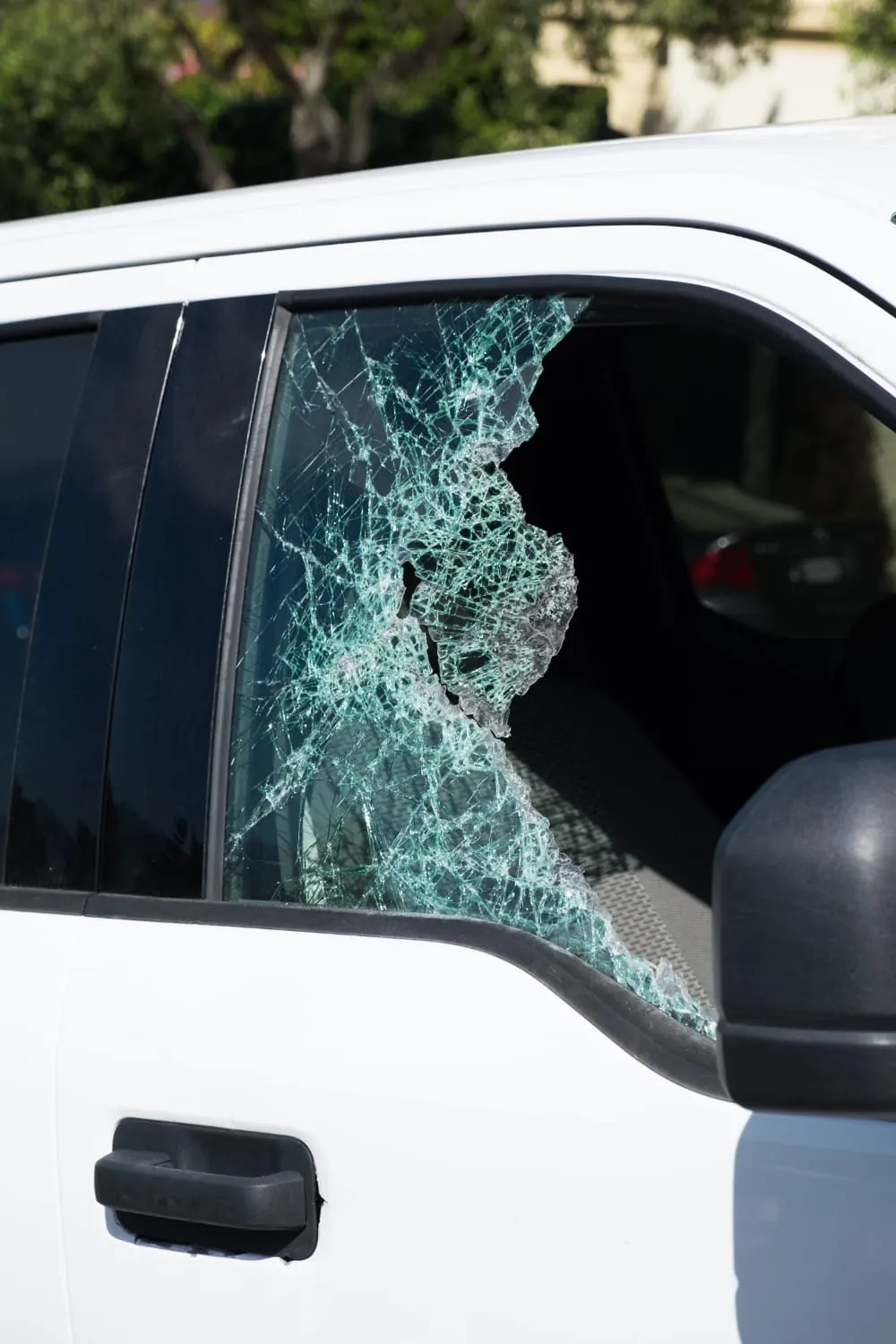 Shattered side window of a white truck