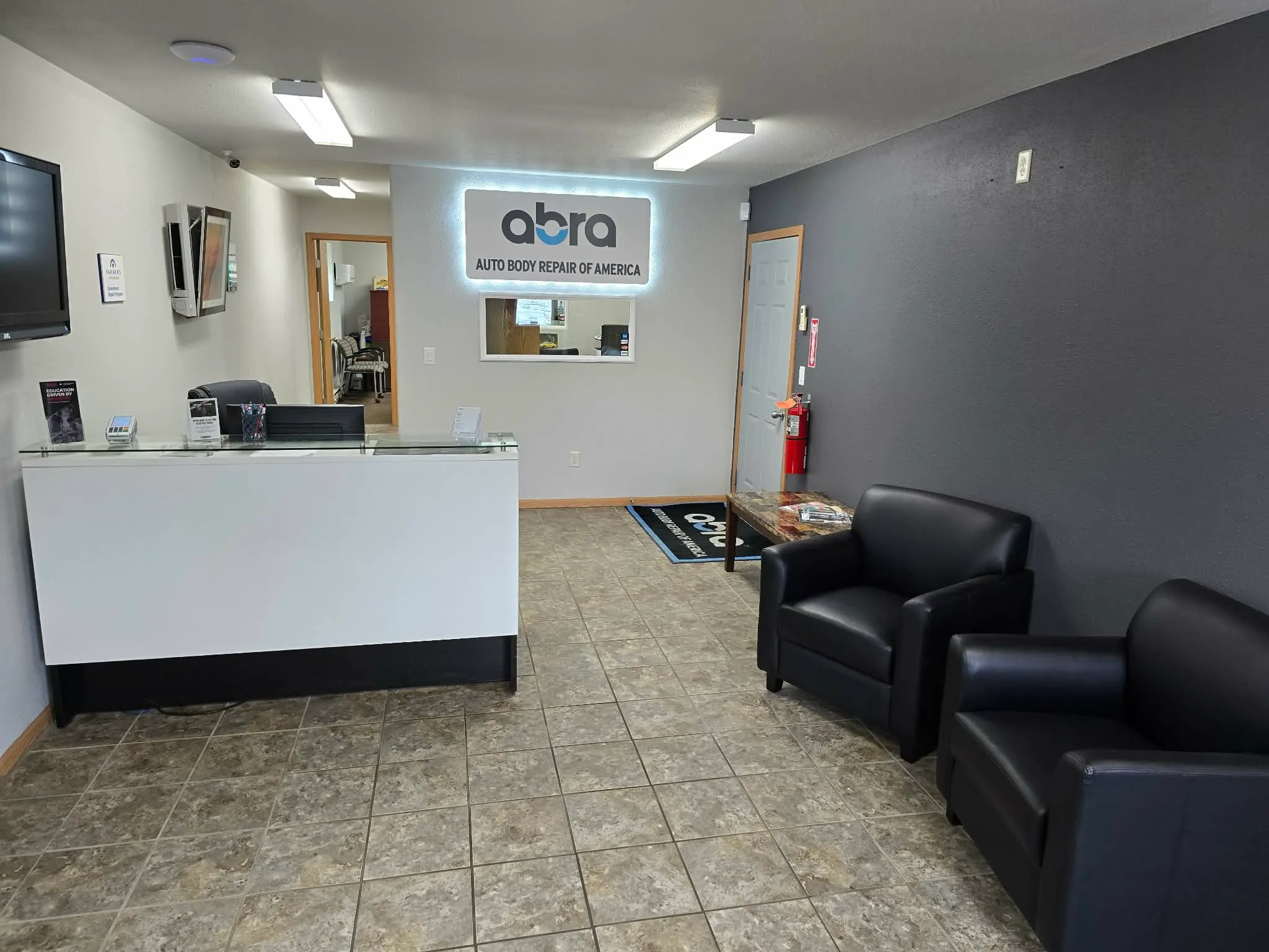 Moorhead shop waiting area with a reception counter and two black chairs