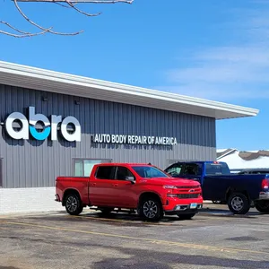 Shop building with the ABRA sign and a red pickup parked in front, square crop