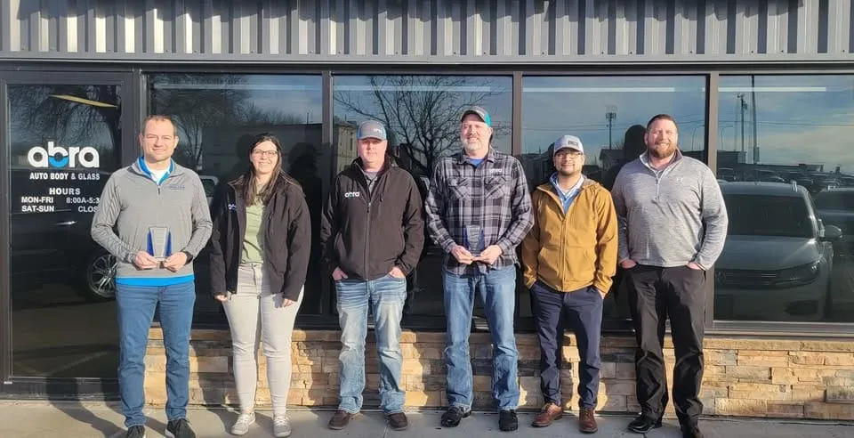 Six ABRA team members standing in front of the shop windows