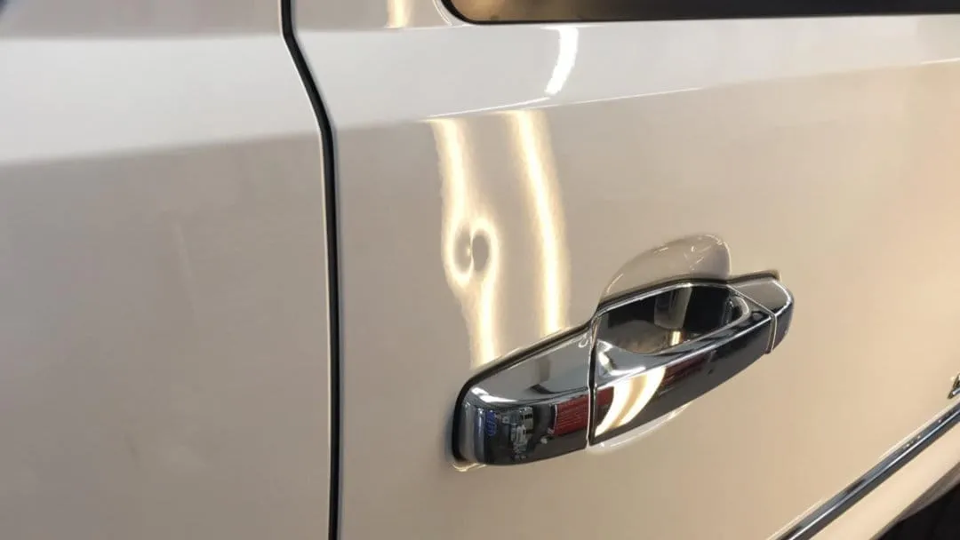 Dent in the door of a silver truck
